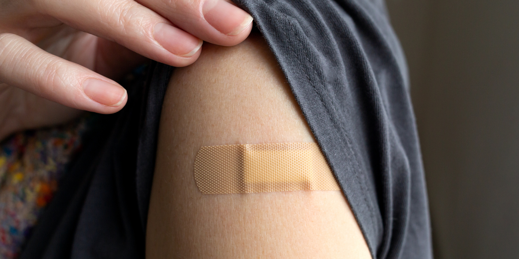 Closeup image of a person with a band aid on their arm.